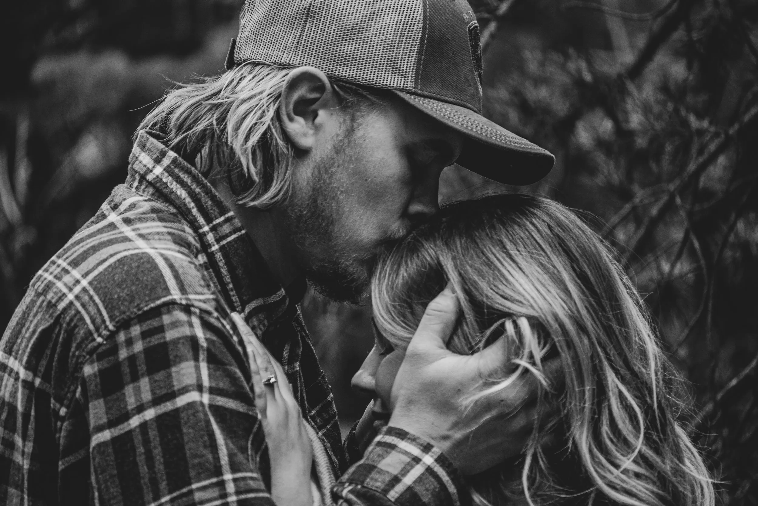 Engaged couple laughing together outdoors