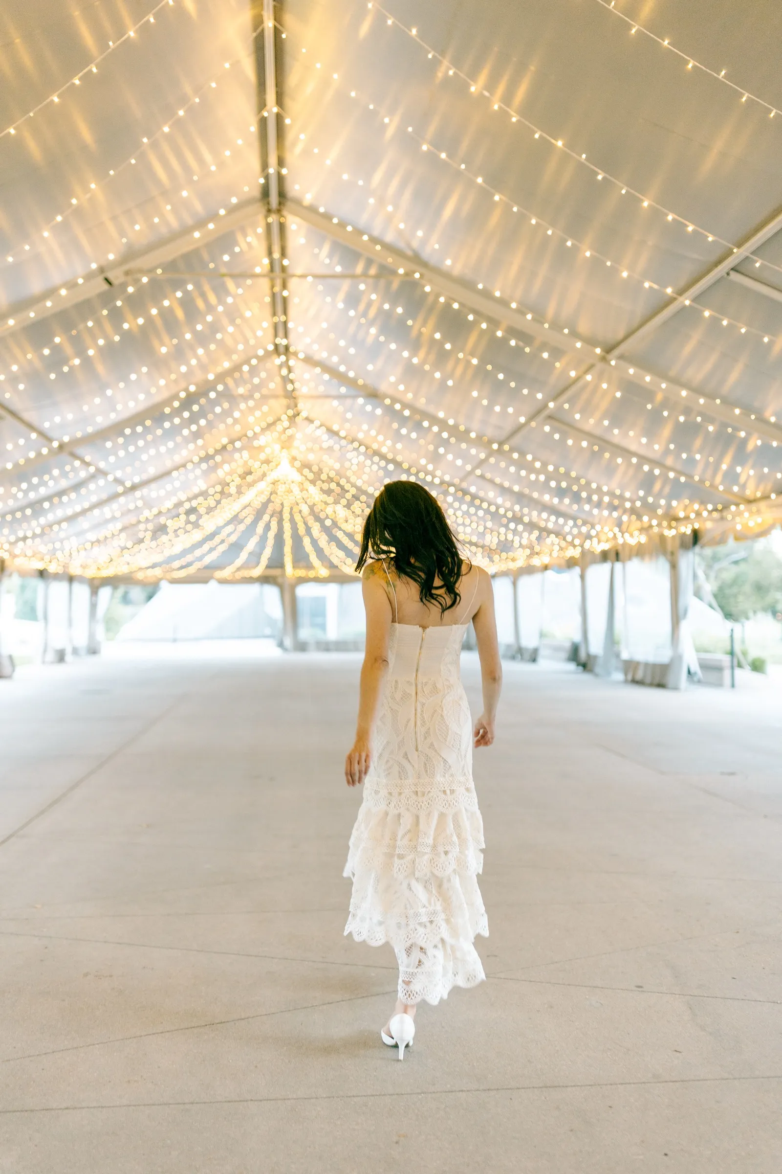 Bride walking away under the lights